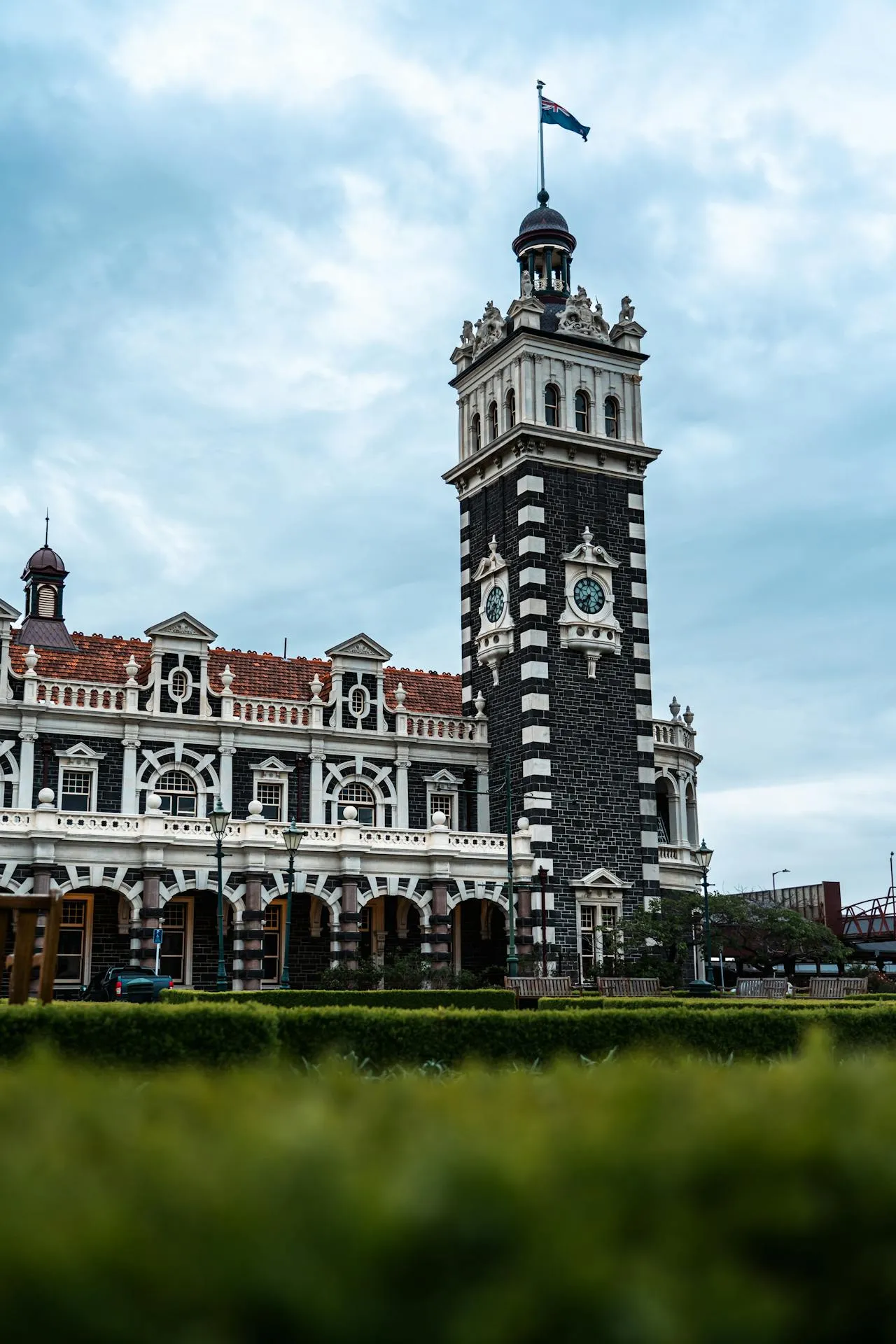 Historic Dunedin Railway Station with its iconic Flemish Renaissance clock tower and black basalt and white Oamaru limestone facade in New Zealand