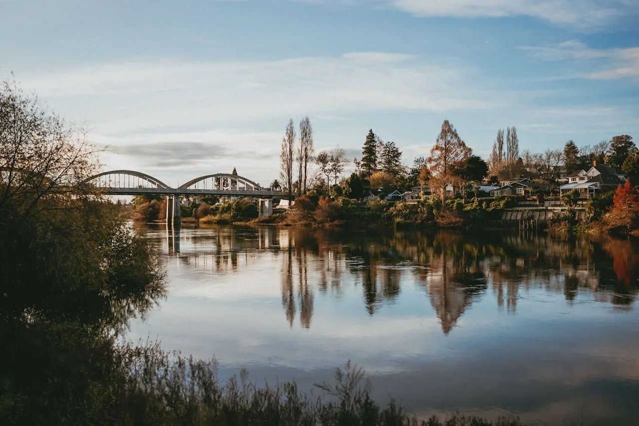 Waikato River in autumn with the Fairfield Bridge reflected in calm water in Hamilton New Zealand